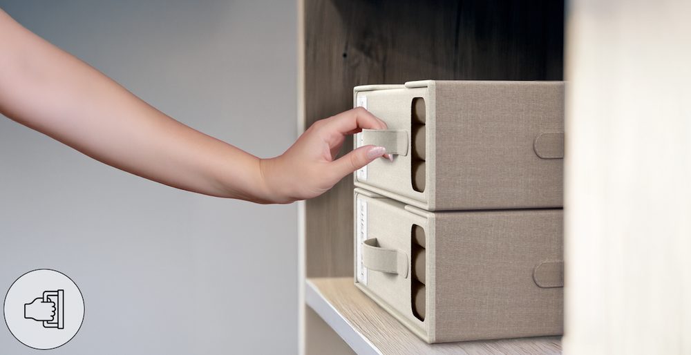 Hand lifting a beige bed sheet organizer by its reinforced linen handle